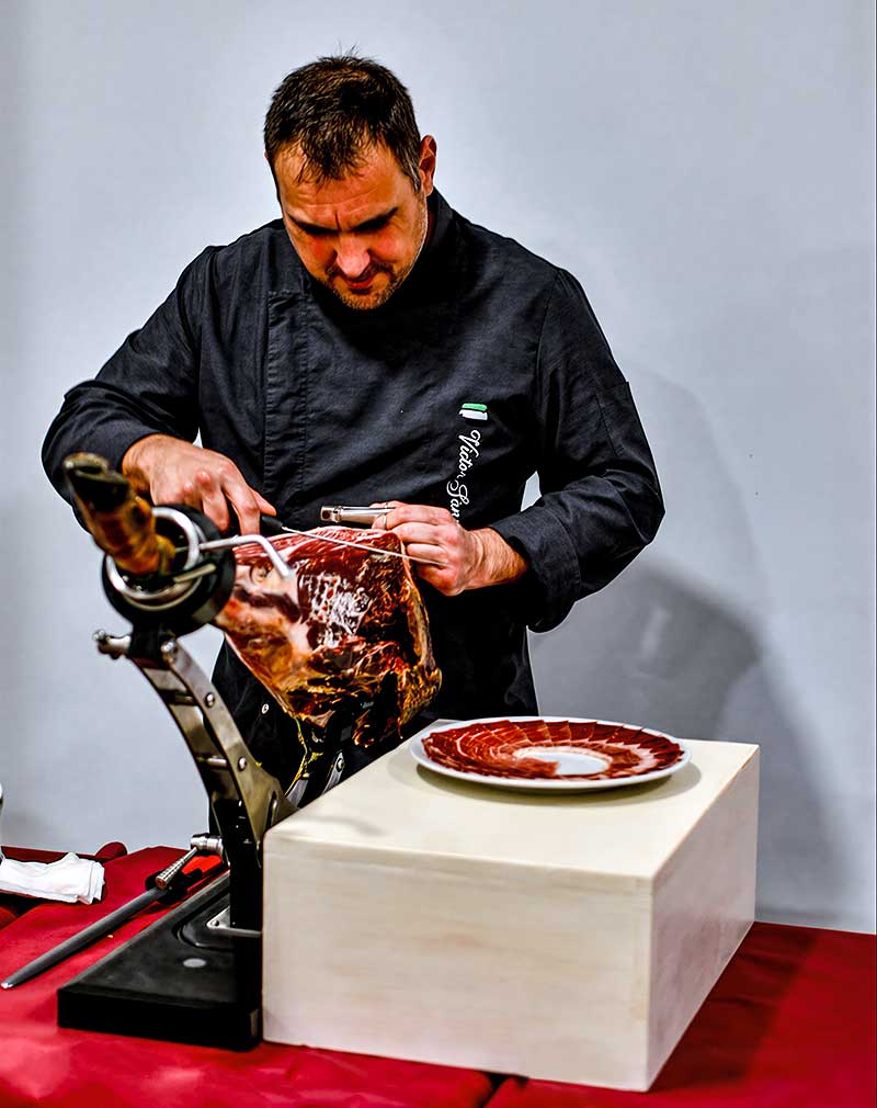 Un cortador de jamón profesional cortando jamón.