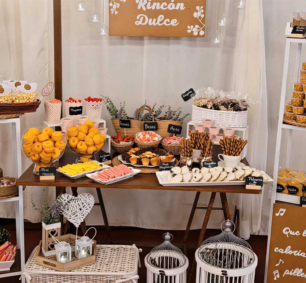 Mesa de dulces decorada al estilo rústico, con gran variedad de dulces.